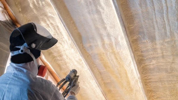 Intérieur en cours de rénovation avec pose de revêtement de sol stratifié gris clair partiellement installé sur chape béton brute